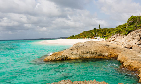 view at rugged rocky seashore and white sand empty beach at anguilla, island in caribbean sea (Photo via noblige / iStock / Getty Images Plus)