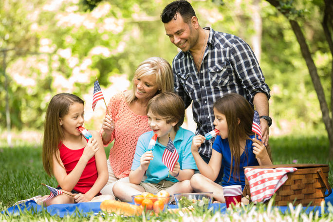 Family celebrating a U.S. national holiday with an outdoor picnic.