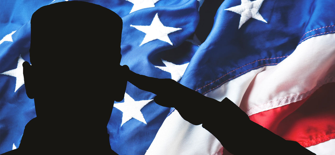 Image: Proud saluting soldier on American flag background. (photo via Anchiy / iStock / Getty Images Plus)