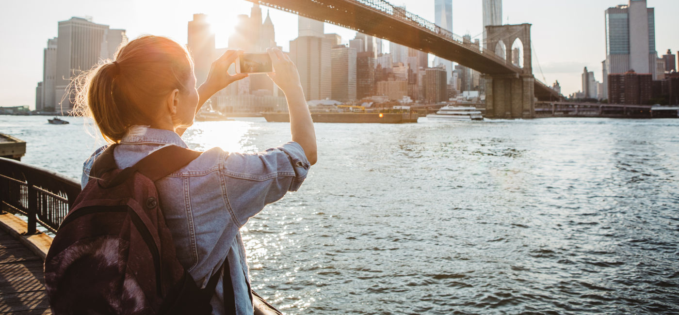 Image: Traveler in New York City taking a picture (Source: Getty/ svetikd)